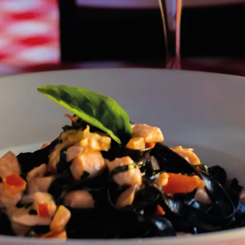 Pasta de la casa con salsa, vegetales y albahaca