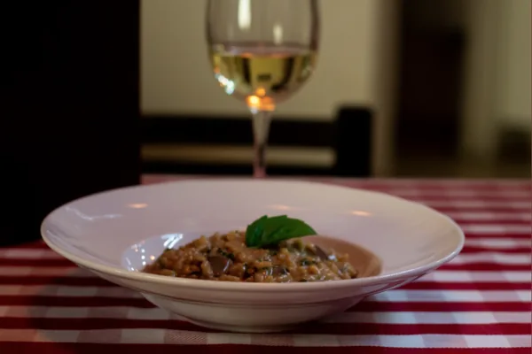 Risotto cremoso junto a una copa de vino blanco